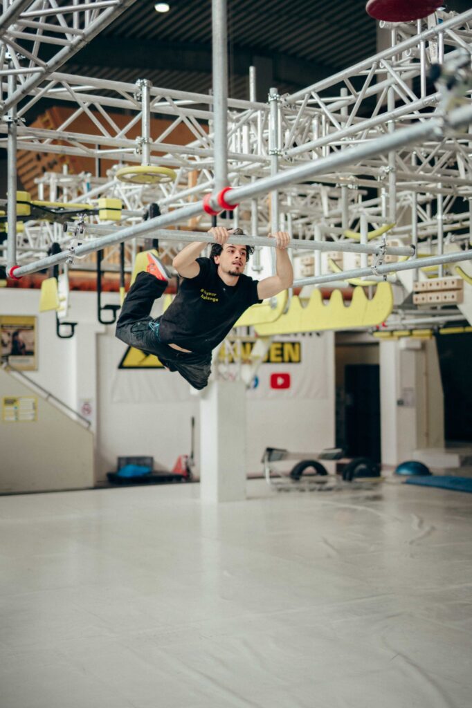 Jugendlicher hangelt sich durch den Ninja-Parkour im Stuntwerk Senden